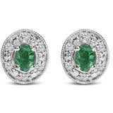 Aretes de botón de halo con esmeralda verde ovalada y diamantes de 1/10 ct. p.t. en oro blanco de 14K