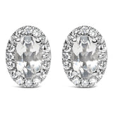 Aretes de botón de halo con piedra natal talla ovalada de 5x3mm y diamantes en oro blanco de 10K