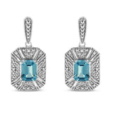Aretes colgantes estilo halo Art Déco con topacio azul talla esmeralda de 7x5mm y detalle de diamante en plata de ley