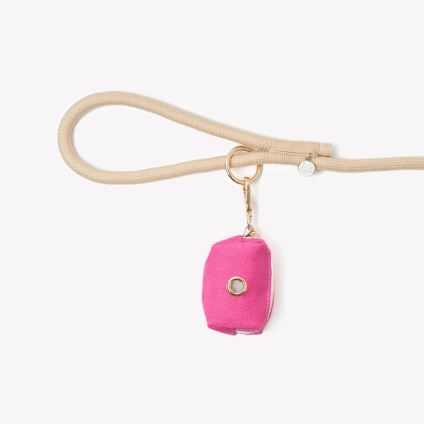 Magenta poop bag holder clipped to a leash handle