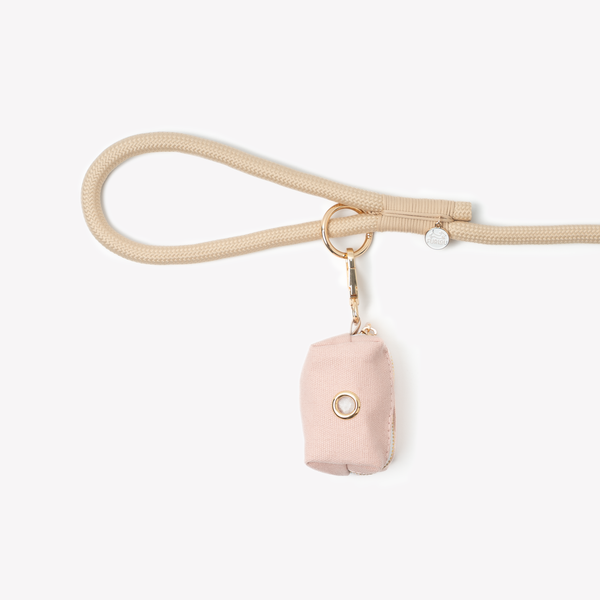 Baby Pink poop bag holder clipped to a leash handle