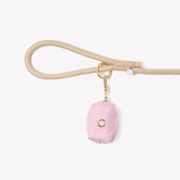 Pink poop bag holder clipped to a leash handle