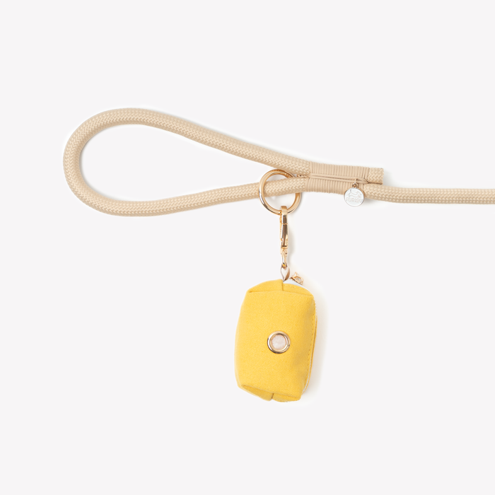 Yellow poop bag holder clipped to a leash handle