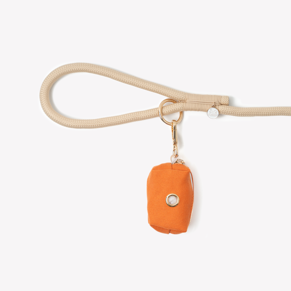 Terracotta poop bag holder clipped to a leash handle