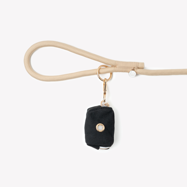 Black poop bag holder clipped to a leash handle