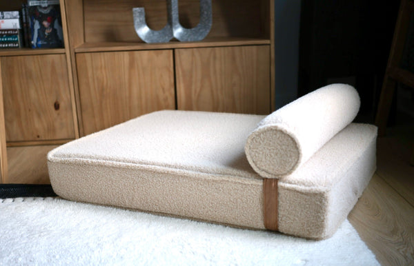 Modern Day boucle dog bed with its bolster on a white rug