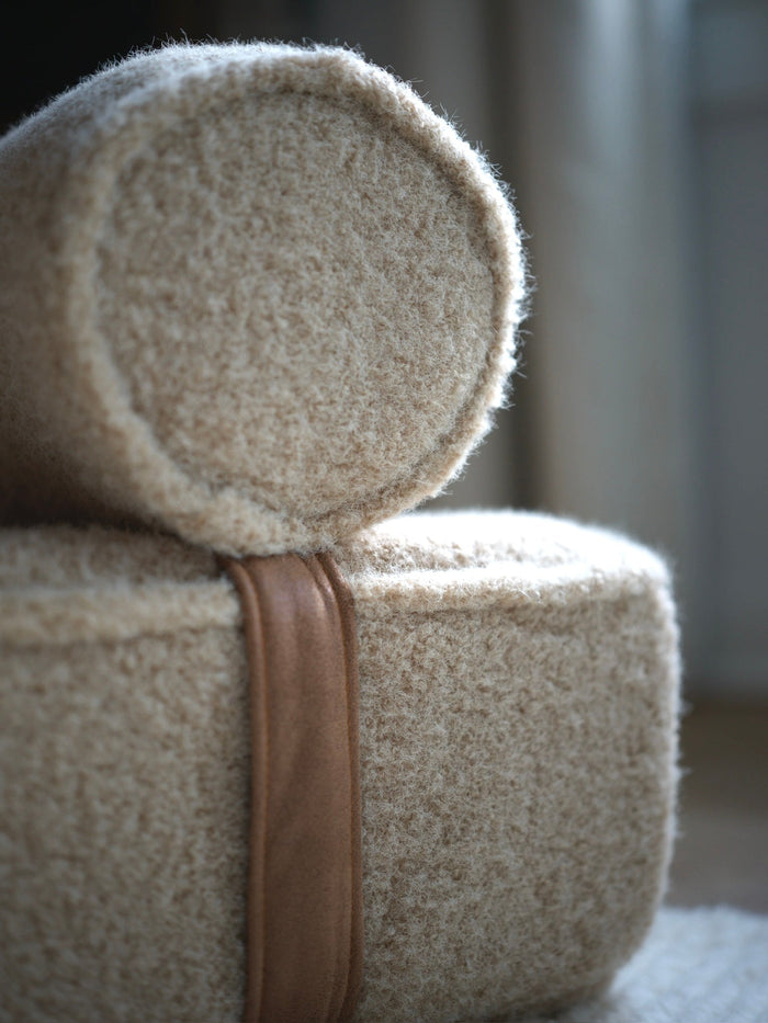 Close-up of the boucle bolster and brown strap on the Modern Day dog bed