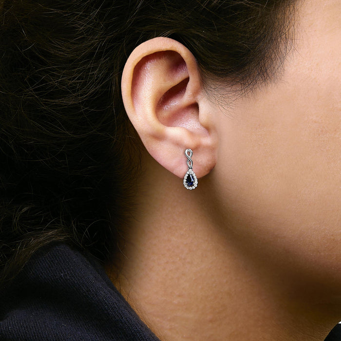 Aretes colgantes de infinito con zafiro azul de talla pera y diamantes de 1/7 ct. p.t. en oro blanco de 10K, foto 3