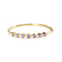 Brazalete rígido de bisel alterno con tanzanita ovalada de 5 mm y diamantes de 1/5 ct. p.t. en oro amarillo de 14K, foto 1