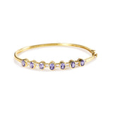 1/5 Ct. T.W. Alternating Bezel-Set 5mm Oval-Shaped Tanzanite and Diamond Bangle Bracelet in 14K Yellow Gold