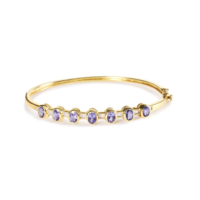Brazalete rígido de bisel alterno con tanzanita ovalada de 5 mm y diamantes de 1/5 ct. p.t. en oro amarillo de 14K, foto 1