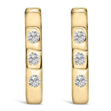 Aretes de aro Huggie ovalados de tres piedras con diamantes cultivados en laboratorio de 1/10 ct. p.t. en oro de 10K