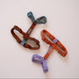 Three strap dog harnesses laid flat, including the Blue and Clay