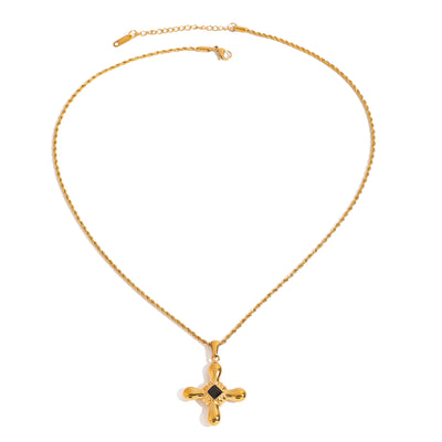 Gold tone pendant necklace, 18K gold plated, on a fine cable chain with a rounded cross pendant and black center accent, lobster clasp and extender visible, no other stones visible.