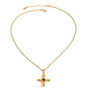 Gold tone pendant necklace, 18K gold plated, on a fine cable chain with a rounded cross pendant and black center accent, lobster clasp and extender visible, no other stones visible.