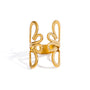 Gold tone cuff ring, 18K gold plated, with mirrored bow-like loop shapes and smooth rounded edges, open cuff construction, high-polish finish, and no stones visible.
