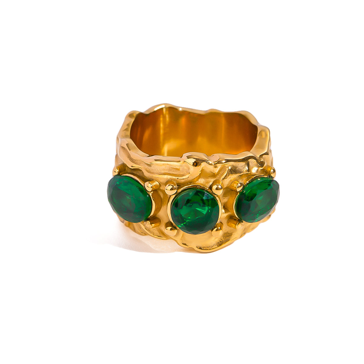 Gold tone statement ring, 18K gold plated, with a molten-textured wide band featuring three deep emerald-tone round stones in bezel settings, no other stones visible.