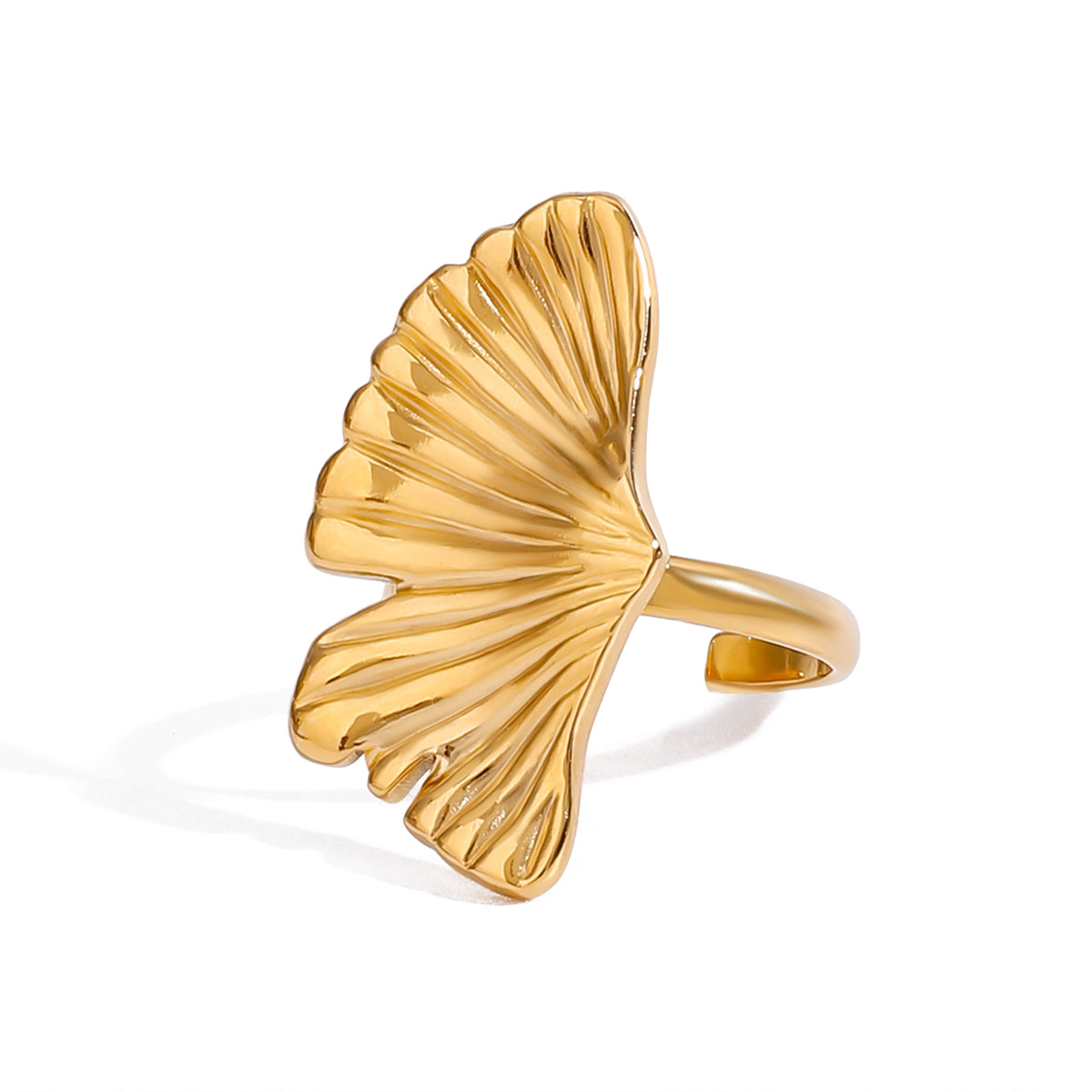 Gold tone statement ring, 18K gold plated, with a ginkgo leaf fan motif featuring crisp pleated ridges and a mirror high-polish finish, open cuff construction, no stones visible.