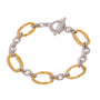 Two tone gold tone and silver tone chain bracelet, 18K gold plated, with oversized oval links and smaller connector links, toggle clasp visible, no stones visible.