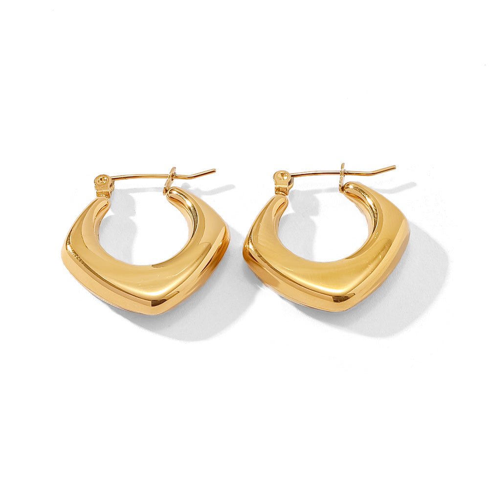 Gold tone huggie hoop earrings, 18K gold plated, in a curved-square sculpted hoop shape with smooth rounded edges and mirror high-polish finish, hinged closure visible, no stones visible.