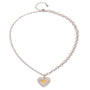 Two tone gold tone and silver tone pendant necklace, 18K gold plated, on a fine cable chain with a ribbed silver heart pendant and glossy gold center heart, lobster clasp and extender visible.