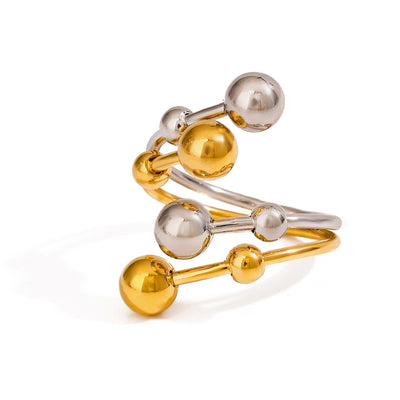 Two tone gold tone and silver tone cuff ring, 18K gold plated, in a wrap design with multiple crossing bands and polished sphere ends in mixed metals, open construction, no stones visible.